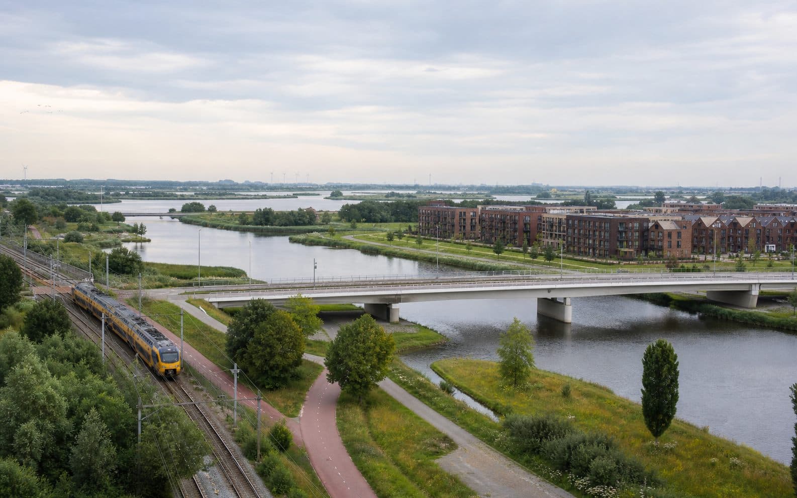 Nederlands landschap met water, woningen, spoor en fietsroute